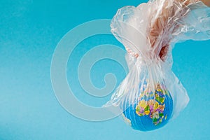 The human hand holds the planet earth in a plastic bag. The concept of pollution by plastic debris. Global warming due to