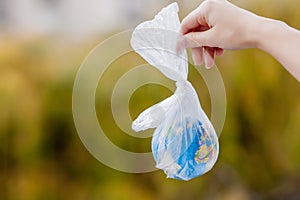 The human hand holds the planet earth in a plastic bag. The concept of pollution by plastic debris. Global warming due to