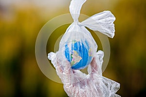 The human hand holds the planet earth in a plastic bag. The concept of pollution by plastic debris. Global warming due to