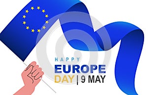A human hand holds the waving flag of Europe. 12 five-pointed yellow stars. 9th May. Happy Europe Day