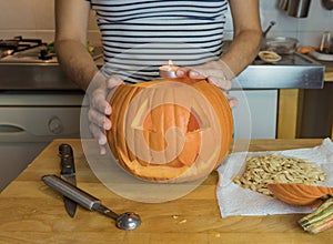 Human hand inserting candle in pumpkin