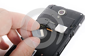 Human hand inserting Micro SD card into cell phone