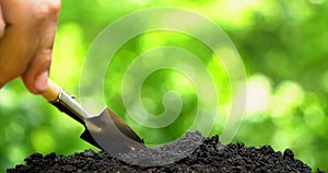 Human hand make hole by shovel, planting seed. Closeup side view on green background