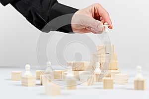 A human hand moving King chess piece at table