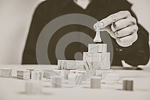 A human hand moving King chess piece at table