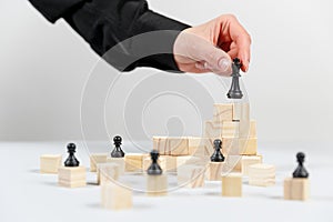 A human hand moving King chess piece at table