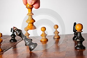 Human hand moving the white queen on a chess board