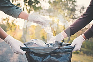 Human hand picking up plastic into bin bag on park ,volunteer co