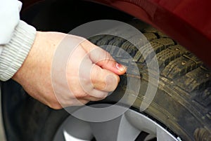 Human hand piercing the tire wheel