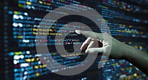 Human hand pointing at the abstract Modern tech of Programming code screen developer