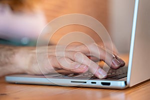 Human hand presses power button on laptop keyboard