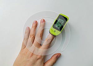 Human hand with a pulse oximeter on the index finger
