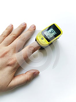Human hand with a pulse oximeter on the index finger close up