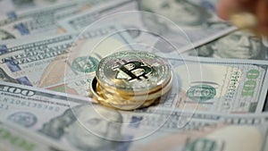 Human hand put gold bitcoin, dash and ethereum coins on dollar banknotes