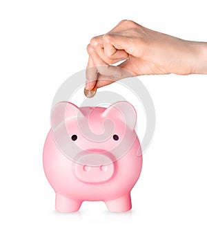 Human hand putting coins in piggy bank on white background. Money saving concept