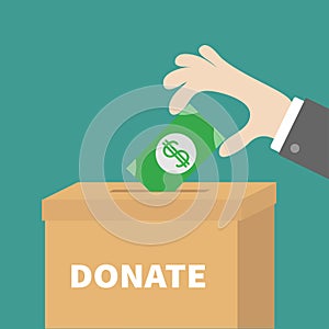 Human hand putting golden coin money with dollar sign into donation paper cardboard box. Helping hands concept. Donate text. Flat