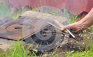 Human hand putting slivers on fire