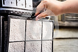 A human hand is removing the filter of an air purifier  for filtering PM2.5. To bring a filter to remove dust