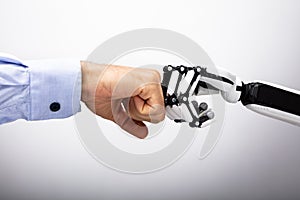 Human Hand And Robot Making Fist Bump