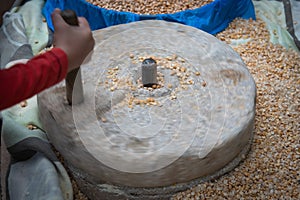 Human hand rotating stone grinding machine for smashing grains. Handmade manual equipment grind mill