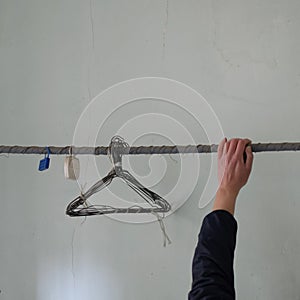 Human hand and rusty wire hangers in abandoned house