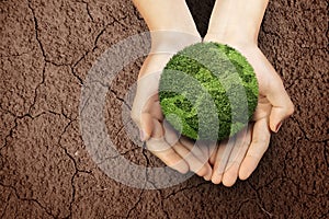 Human hand showing fertile land above the drought field