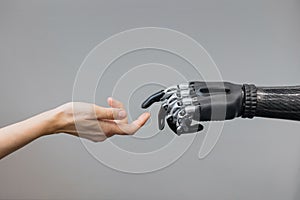 the human hand and the siber hand bionic prosthesis make a handshake and greeting. modern technologies of prosthetics