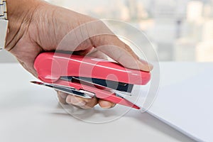 Human hand is stapling the paper