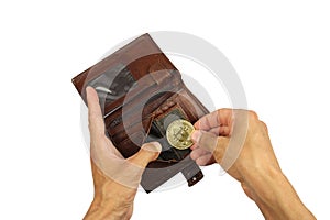 human hand takes or puts golden coin of bitcoin from brown leather wallet, isolated
