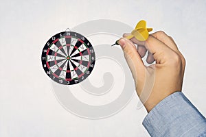 Human hand is throwing the darts target to the darts board