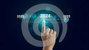 Human hand touch on virtual bar status to change from 2023 to 2024 and 2025 for preparation and focus new business concept,