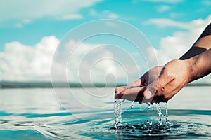 Human hand is touching water on the river
