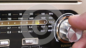 Human hand tuning a vintage radio