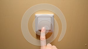 Human hand turn off a power button on a yellow wall