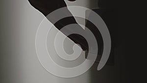 Human hand turning on the light with a switch on the wall