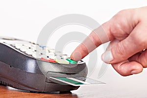 Human hand using payment terminal, credit card reader.