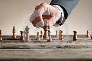 Human hand wearing business suit moving dark King chess piece