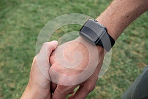 Human hand wearing smart watch. Wearable gadget concept. A couple holding hands. Closeup