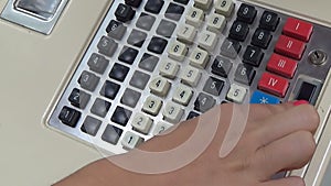 A human hand working old a cash register