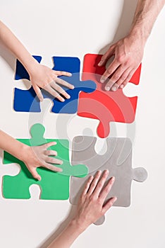 Human hands on colorful puzzle pieces