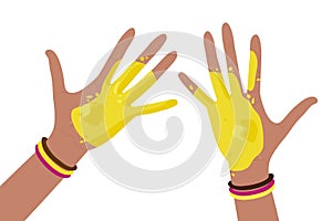 Human hands covered with yellow paint wearing bright multicolored bracelets. Happy Holi Spring Holiday of India. Holiday