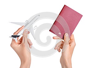 Human hands holding airplane and red passport on white background. Flight, travel concept