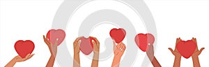 Human hands holding and giving red hearts. Concept of sharing love, compassion with people. Love symbols banner