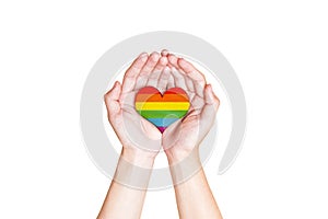 Human hands holding heart with rainbow flag as a symbol of LGBT