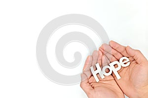 Human hands holding hope word cutout in white background. Top view with copy space.