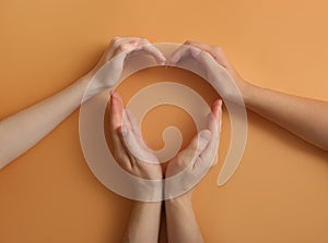 Human hands making heart on color background. Polyamory concept photo