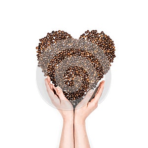 Human hands making heart symbol made from coffee seeds