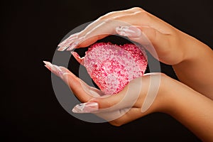 Human hands with manicure hold pink heart