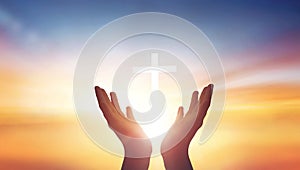 Human hands open palm up worship god on Sunset background with cross on white