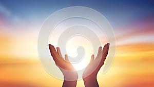 Human hands open palm up worship at sunset Sky background